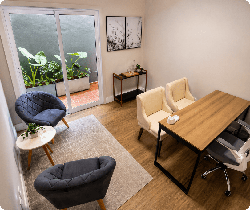 Sala privativa com mesa de trabalho, poltronas e entrada de luz natural